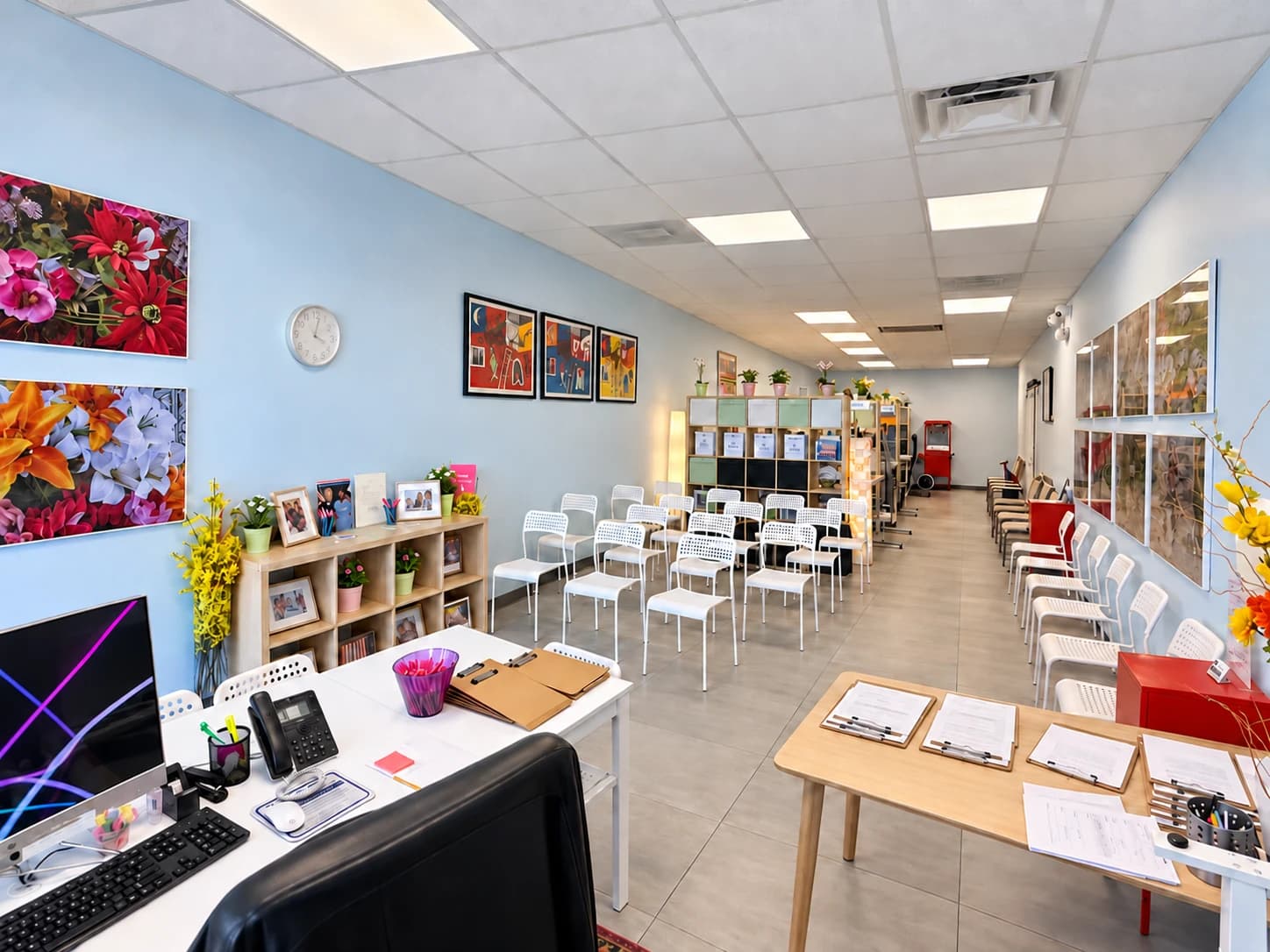 Inside the Manors Medicaid office: a reception desk, rows of white chairs, and colorful framed art