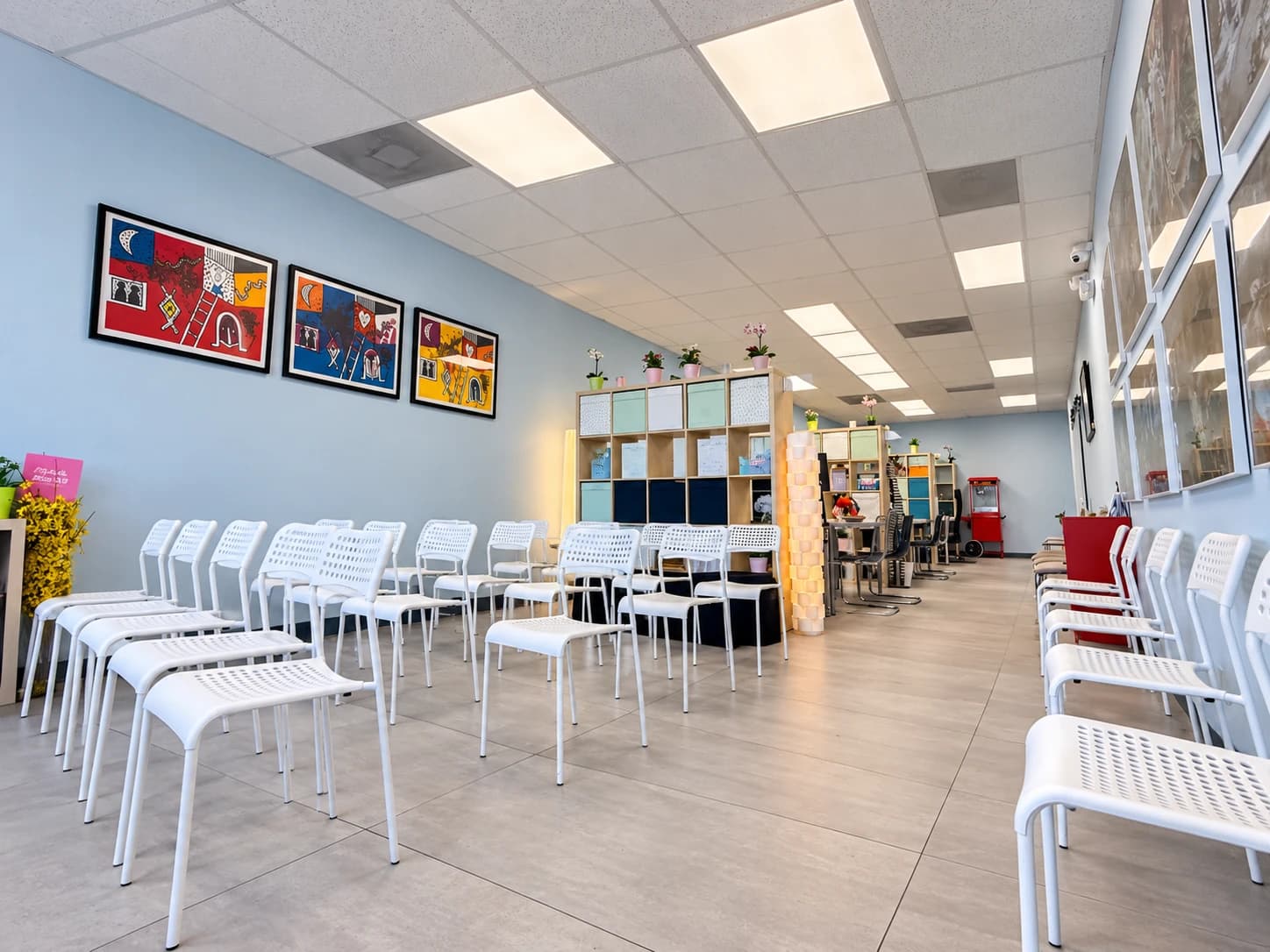 Inside the Manors Medicaid office: a bright waiting area with rows of white chairs and colorful framed art